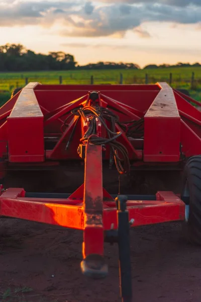 Ένα Κάθετο Πλάνο Ενός Κόκκινου Τρακτέρ Ένα Καλλιεργούμενο Χωράφι Ηλιοβασίλεμα — Φωτογραφία Αρχείου