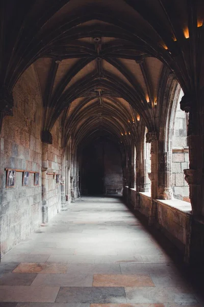 Eski bir manastırın kemerleriyle boş bir koridorun dikey görüntüsü..