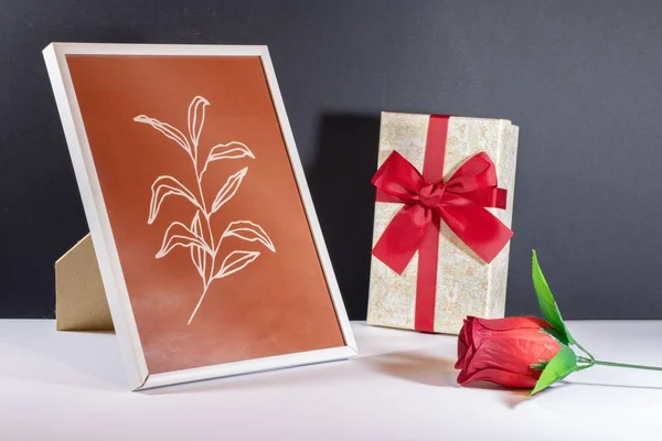 Крупный План Маленькой Подарочной Коробочки Искусственной Розой Фоторамкой Столе — стоковое фото
