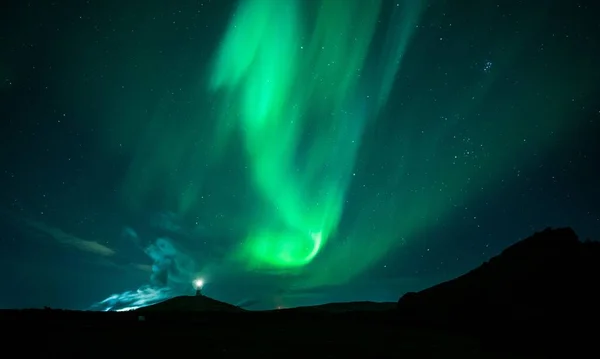 冰岛雷克雅内灯塔上方的北极光迷人的景象 — 图库照片