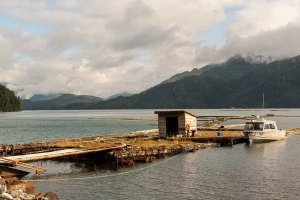 背後の埠頭と山に避難所がある古い埠頭に結び付けられた船 — ストック写真