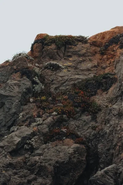凹凸のある溶岩石の垂直クローズアップ暗い空の背景 — ストック写真