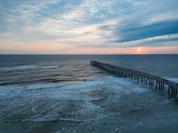 魅力的な夕日の景色波の海と長い桟橋 — ストック写真