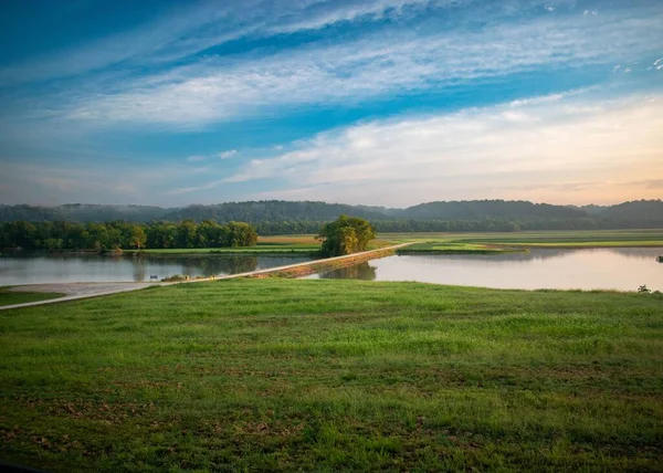 青空の下での湖や緑の畑の美しい景色 — ストック写真