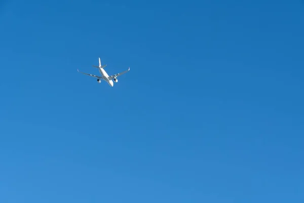 Ένα Λευκό Αεροπλάνο Που Πετάει Απομονωμένο Στο Καθαρό Γαλάζιο Ηλιόλουστο — Φωτογραφία Αρχείου