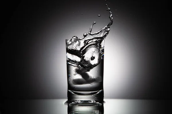 Eine Graustufen Nahaufnahme Eines Wasserglases Mit Spritzern Aus Fallenden Eiswürfeln — Stockfoto