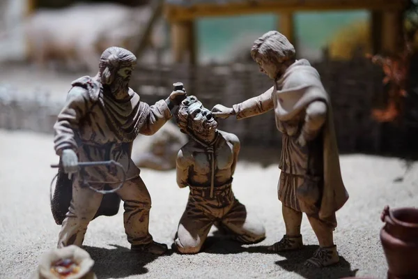 Closeup Small Sculptures Ancient Men Punishing Another Person Sand Blurry — Stock Photo, Image