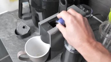 Kahve makinesini kahve yapmak için kullanan birinin yakın çekim görüntüsü.