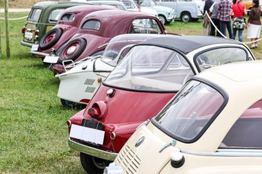 Açık hava etkinliği sırasında arka arkaya park edilmiş birkaç klasik arabanın görüntüsü