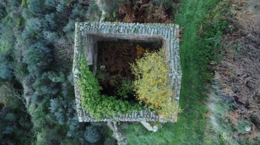 Sonbaharda bir tepede tamamlanmamış bir kare inşaatın üst görüntüsü.