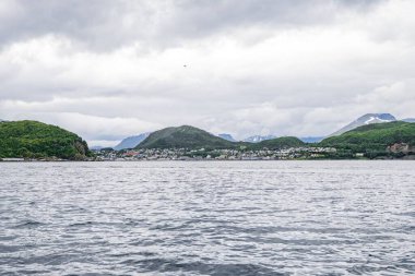 Güzel bir deniz manzarası ve arka planda kayalıklar olan bulutlu gökyüzü.