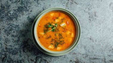Masadaki portakallı lezzetli çorbanın üst görüntüsü.