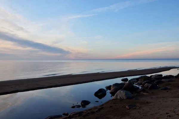 穏やかな海の青い海と青い空の下で海岸沿いの石 — ストック写真