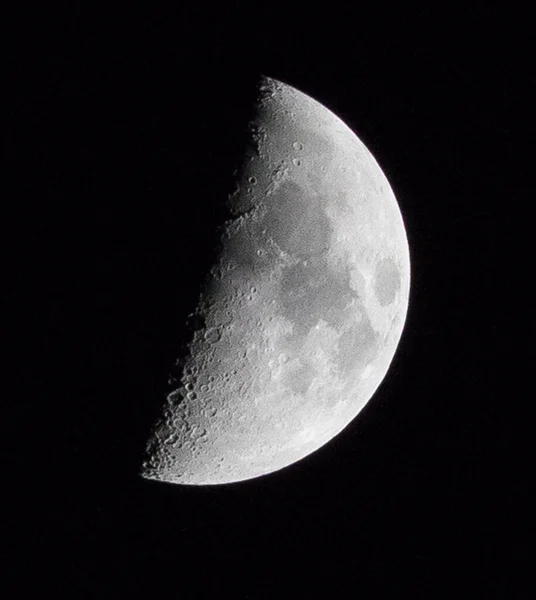 半月形半月形的竖直的宏观照片 其详细的表面在晴朗的黑暗的天空中 — 图库照片