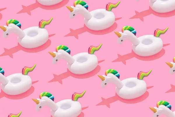 A 3D of inflatable unicorn pool toy pattern on a pastel pink background - summer concept