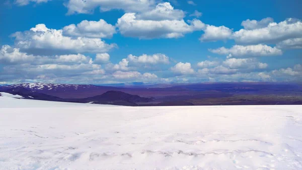 部分的に曇った空の下で風景の前に雪に覆われたフィールドの景色 — ストック写真
