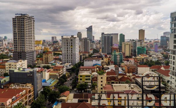 An aerial shot of Phnom Penh capital city of Vietnam with many buildings under a cloudy sky