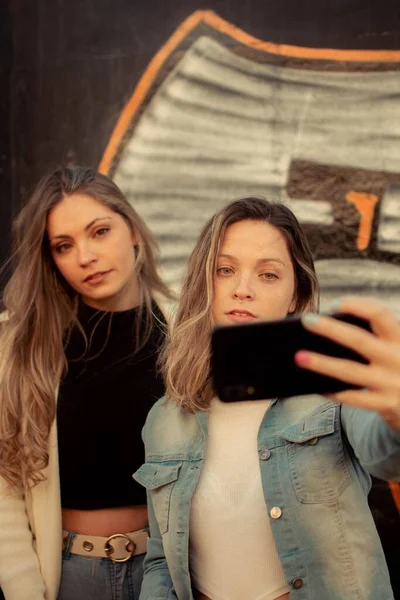 Vertikal Bild Två Kvinnliga Vänner Som Tar Selfie Mot Graffiti — Stockfoto