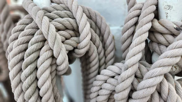 A close-up shot of details of sail rope on the mast of sailboat. Marine equipment, sea knot, journey