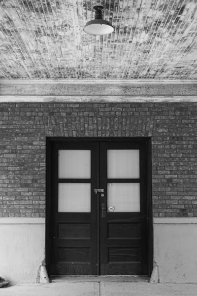 Vertical Grayscale Shot Wooden Doors Stone Wall — Stock Photo, Image