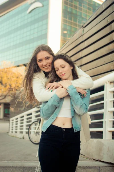 Pionowe Ujęcie Młodej Stylowej Przyjaciółki Przytulającej Się Pozującej Świeżym Powietrzu — Zdjęcie stockowe