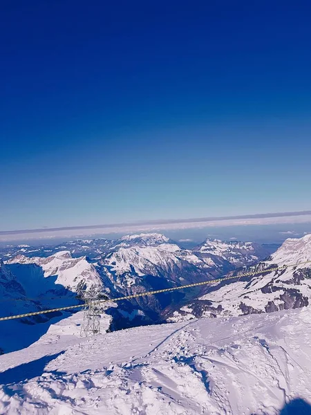 飛行機の窓から見える雪の山の垂直ショット — ストック写真