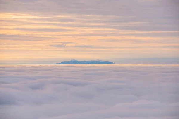 夕暮れ時の雲の中の美しい山の絵のようなショット — ストック写真