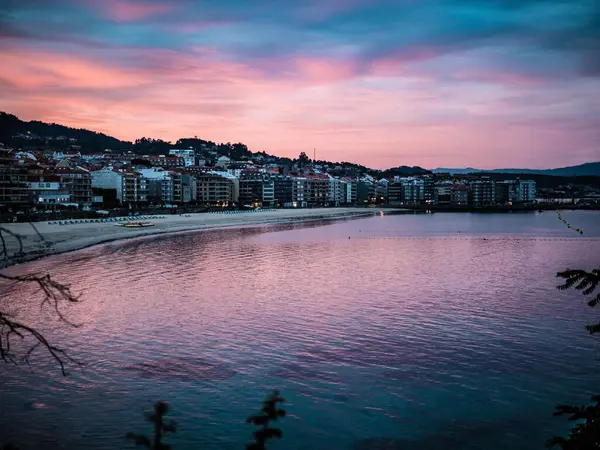 海岸沿いの建物で海の上に魅惑的な夕日の景色 — ストック写真