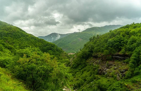 雲に覆われた空を望む緑の丘の風景 — ストック写真