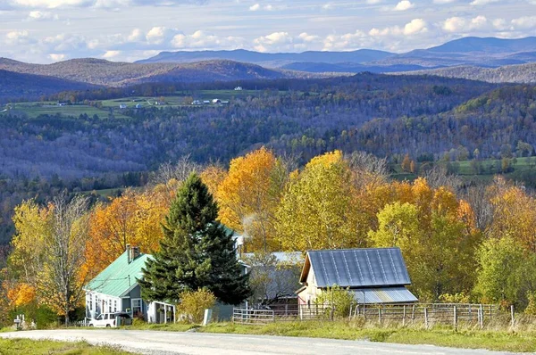 Kuzeydoğu Vermont kırsalında sakin bir köy yolu. Dağların, çiftlik binalarının ve renkli sonbahar yapraklarının geniş manzarası var..