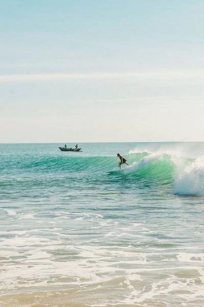 Arka Planda Teknesi Olan Büyük Dalgalarda Sörfçünün Dikey Görüntüsü — Stok fotoğraf