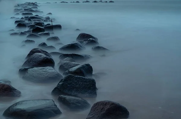 リトアニアのパランガビーチの岩の上の波の長い露出ショット — ストック写真