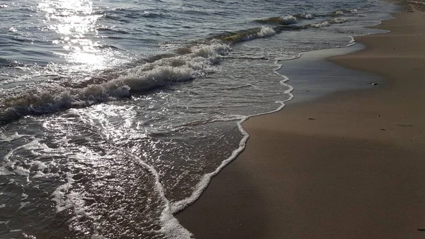 在阳光下被海浪环绕的海滩景观 — 图库照片