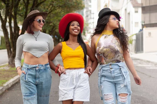 Grupa Trzech Młodych Przyjaciółek Karnawałowych Kapeluszach Spacerujących Ulicach Bawiących Się — Zdjęcie stockowe