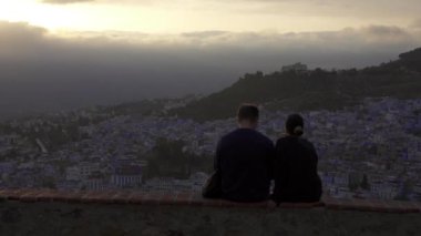 Chefchaouen, Fas 'ta gün batımını izleyen bir çiftin yakın çekim görüntüsü.