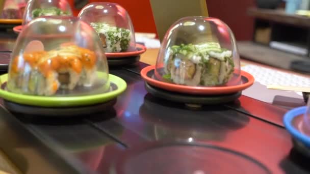 Een Close Shot Van Borden Van Sushi Verhuizend Een Helling — Stockvideo