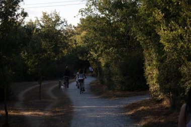 İspanya 'nın Vitoria Gasteiz kentindeki Zabalgana parkında yürüyen ve bisiklete binen insanların arka plan görüntüleri