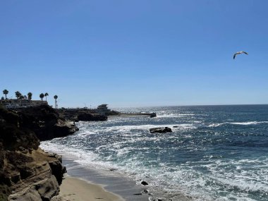 Yazın güneşli bir günde La Jolla Cove San Diego sahilinin üzerindeki mavi gökyüzü