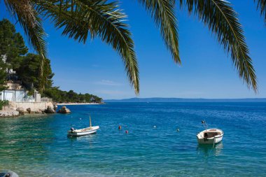 Deniz yüzeyinde tekneleri olan bir sahilin manzarası.