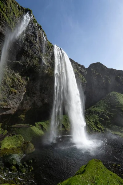 Низкоугольный Снимок Водопада Сельджаландсфосс Исландии Красивыми Скалами Покрытыми Зеленым Мхом — стоковое фото