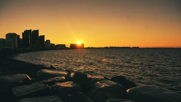 Die Silhouetten Der Küstengebäude Vor Einem Orangefarbenen Sonnenuntergang — Stockfoto
