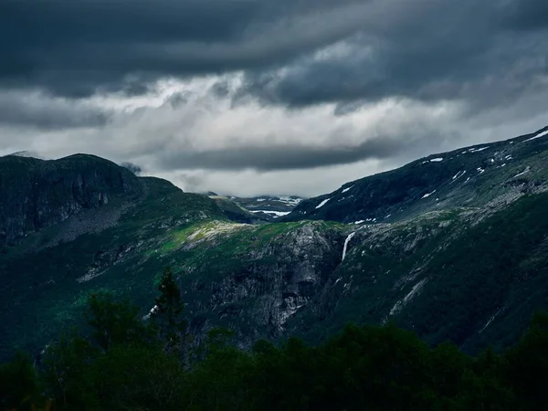 Yeşil Çimlerle Kaplı Karlı Bir Dağın Tepesi Arka Planda Fırtınalı — Stok fotoğraf