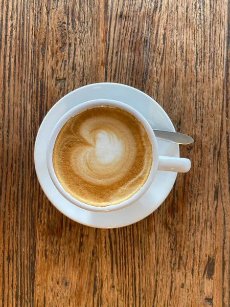 Bovenaanzicht Van Een Gedecoreerde Koffiekop Van Schuim Een Witte Plaat — Stockfoto