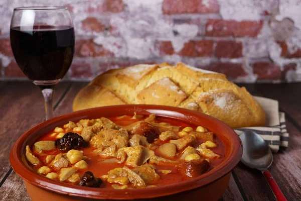 粘土砂锅 有马德里风格的炖菜 典型的西班牙食物在木制桌子上 背景是砖墙 — 图库照片