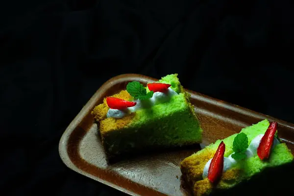 Een Bovenaanzicht Van Pluizige Stukjes Groene Cake Houten Dienblad Zwarte — Stockfoto