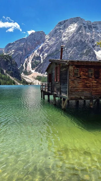イタリアのPragser Wildsee湖と背景にある小さな木造の家と山 — ストック写真