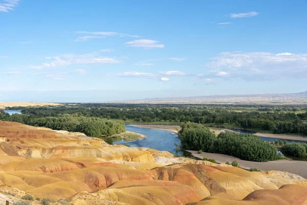 stock image A scenic shot of the colorful and rocky beach of Xinjiang in China surrounded by green trees