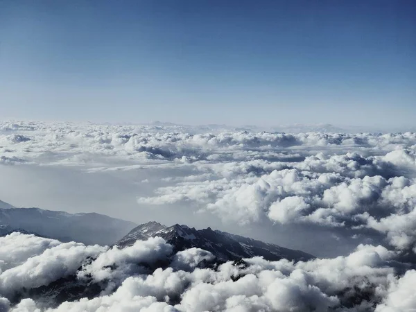 大きな山の山頂の空中と青い空の下で白い雲の上の美しい景色 — ストック写真
