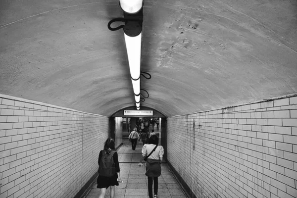 トンネルを歩く人々のグレースケールの景色 — ストック写真