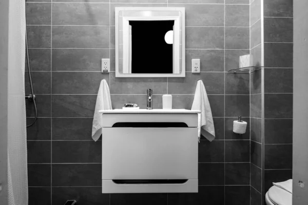 显示镜子 一些悬挂的毛巾 卫生纸 水龙头和墙砖的浴室细节的黑白内景 — 图库照片